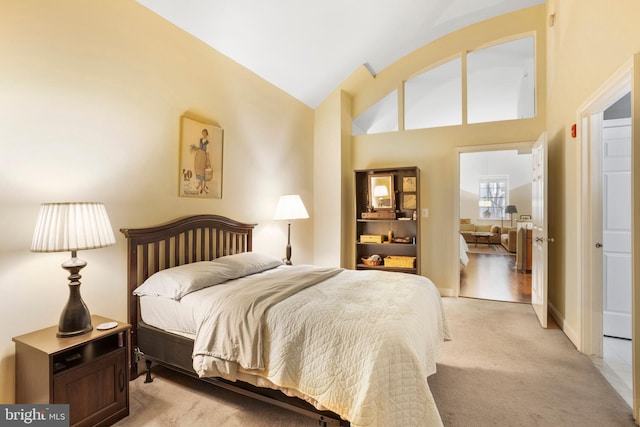 bedroom featuring light carpet, vaulted ceiling, and baseboards