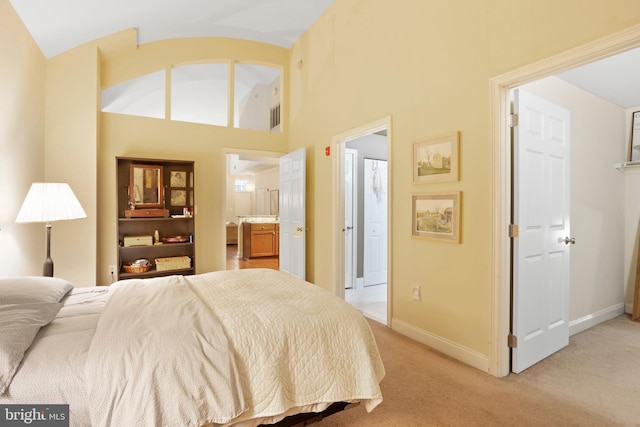 bedroom featuring light carpet, ensuite bathroom, visible vents, and baseboards