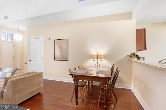 dining room featuring dark wood finished floors, visible vents, and baseboards