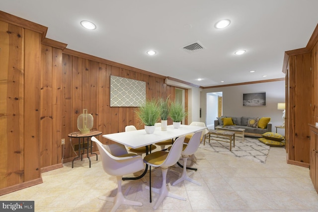 dining area featuring recessed lighting, crown molding, wooden walls, visible vents, and baseboards