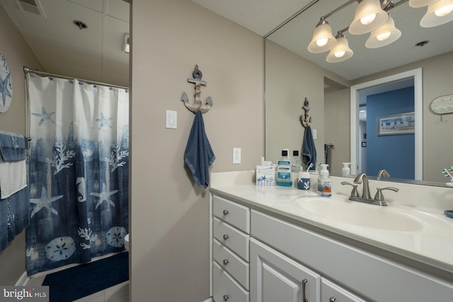 bathroom with curtained shower, visible vents, and vanity