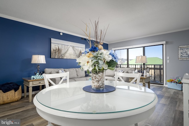 dining area featuring baseboards, dark wood finished floors, and crown molding