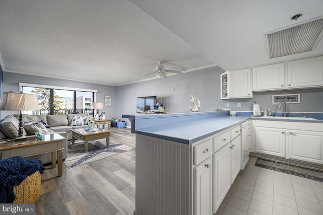 kitchen featuring a peninsula, white cabinetry, open floor plan, light countertops, and open shelves