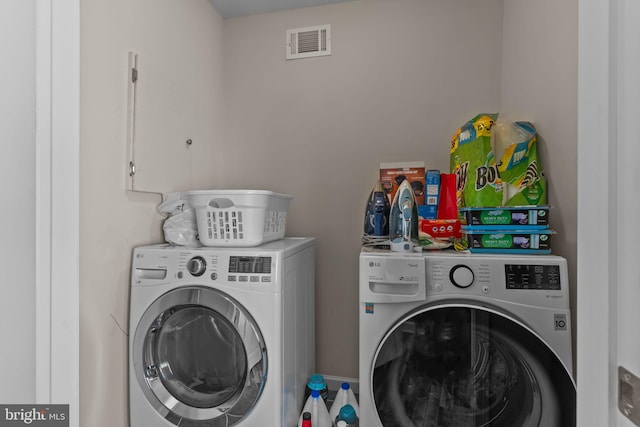 laundry area with visible vents and washer and dryer