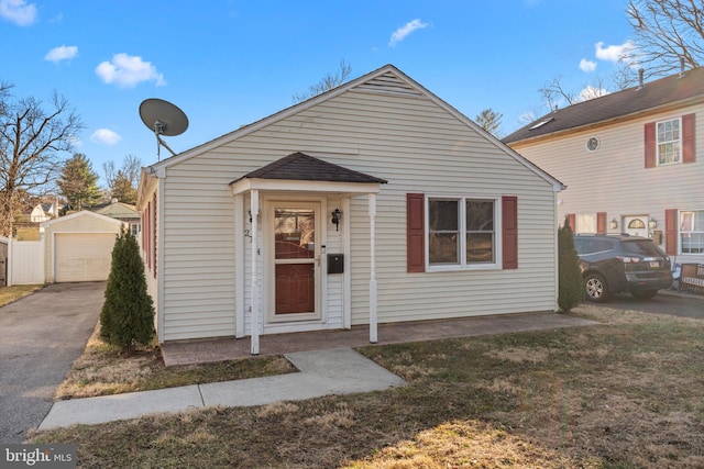 view of front facade with a garage, driveway, an outdoor structure, and a front yard