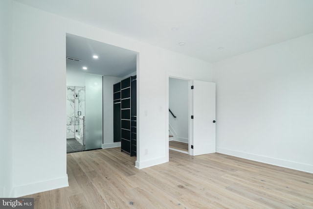 spare room featuring recessed lighting, baseboards, and light wood finished floors