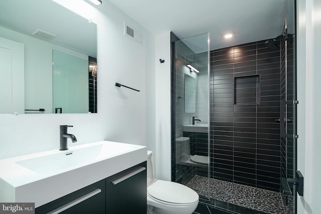 full bathroom with visible vents, a stall shower, vanity, and toilet