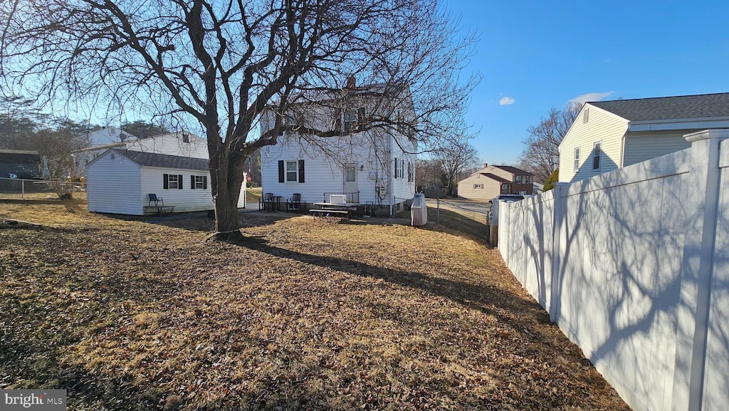 view of yard featuring fence and an outdoor structure