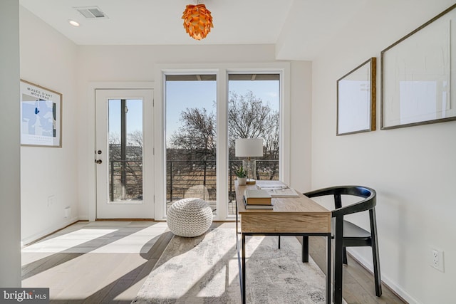 office space featuring light wood-type flooring, baseboards, visible vents, and recessed lighting