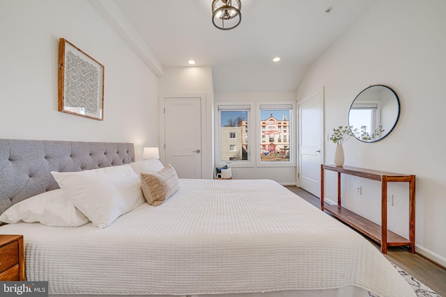 bedroom featuring lofted ceiling, baseboards, wood finished floors, and recessed lighting