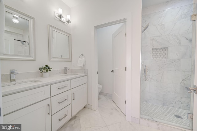 full bathroom featuring toilet, marble finish floor, a sink, and a stall shower