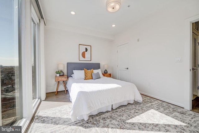 bedroom featuring baseboards, wood finished floors, and recessed lighting