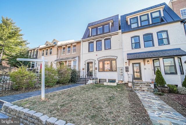 townhome / multi-family property featuring metal roof, brick siding, and a standing seam roof