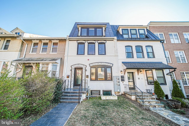 townhome / multi-family property with metal roof, brick siding, and a standing seam roof