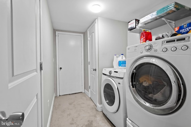 washroom featuring laundry area, washer and clothes dryer, and baseboards