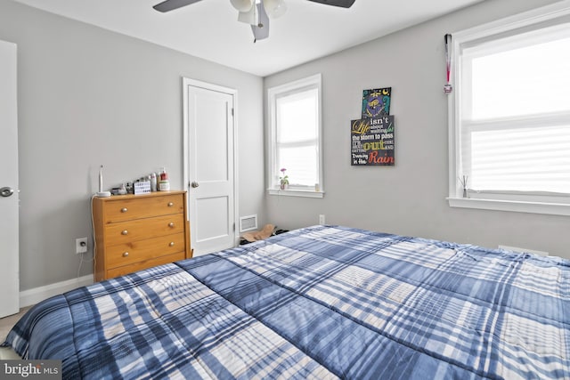 bedroom with baseboards, visible vents, and ceiling fan