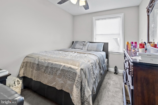 bedroom with ceiling fan, light colored carpet, and baseboards