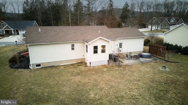 rear view of house with entry steps, roof with shingles, fence, a yard, and central air condition unit