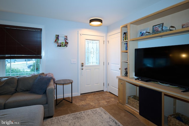 foyer featuring stone finish floor and baseboards