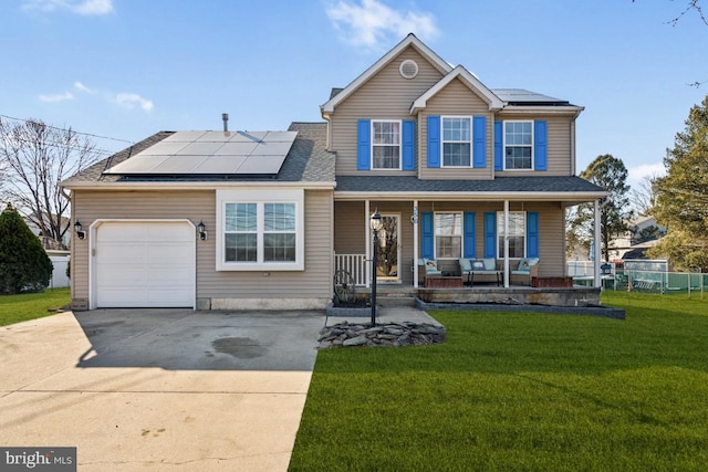 traditional-style house with driveway, solar panels, a porch, an attached garage, and a front lawn