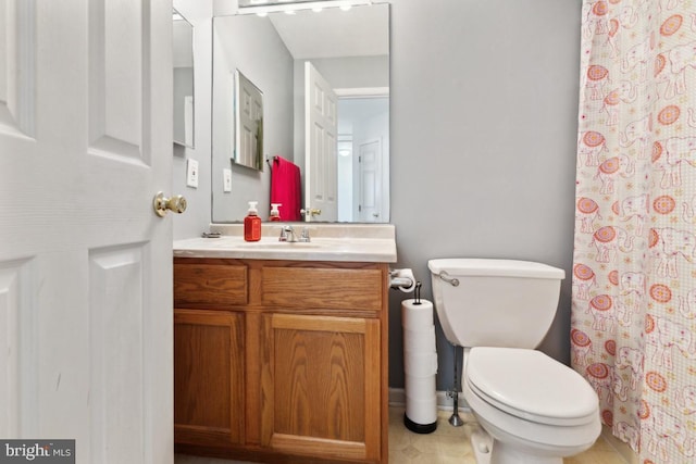 bathroom with a shower with shower curtain, tile patterned flooring, vanity, and toilet