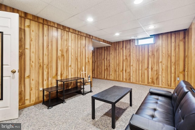 living area with recessed lighting, carpet flooring, and wooden walls