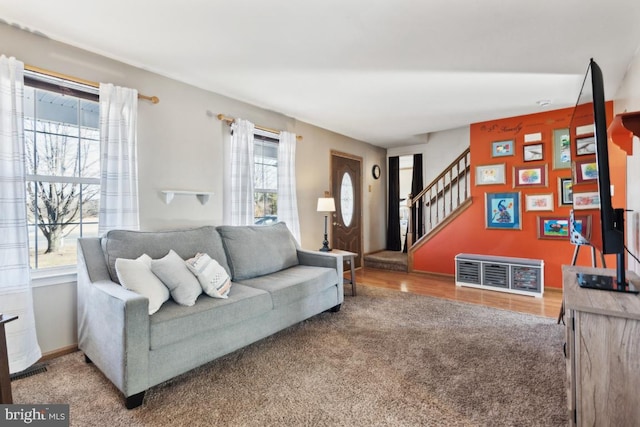 carpeted living room with plenty of natural light, stairway, and baseboards