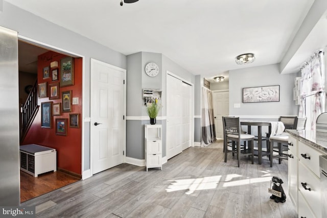 dining space featuring stairs, wood finished floors, and baseboards