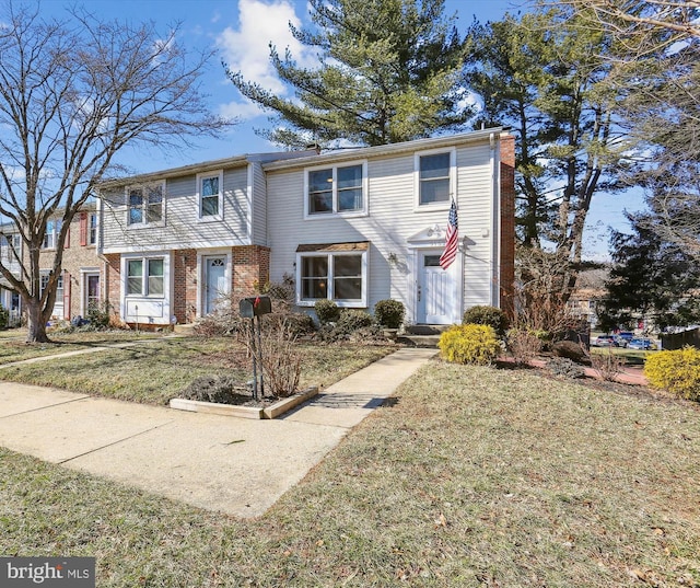 view of property with a front lawn and brick siding