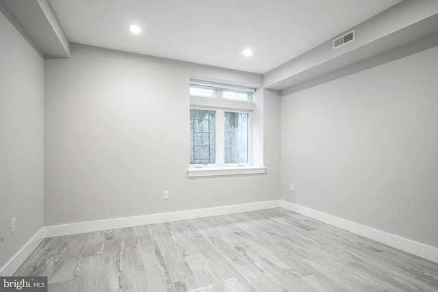 empty room featuring light wood finished floors, visible vents, baseboards, and recessed lighting