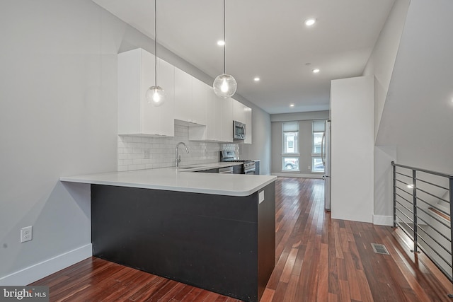 kitchen with light countertops, white cabinets, a sink, modern cabinets, and a peninsula