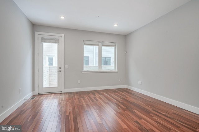 unfurnished room with dark wood-style floors, baseboards, and recessed lighting