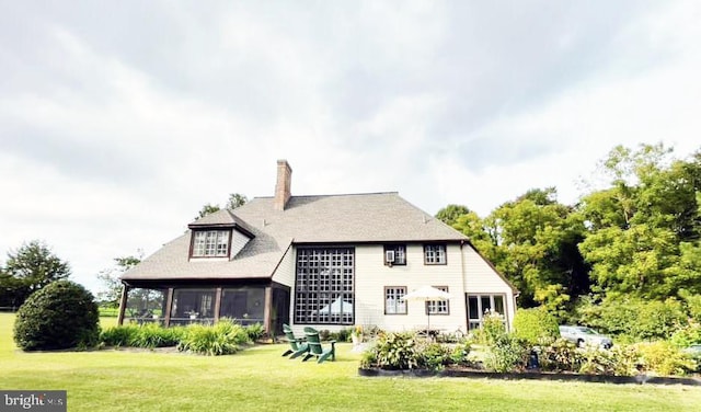 back of house with a lawn and a chimney