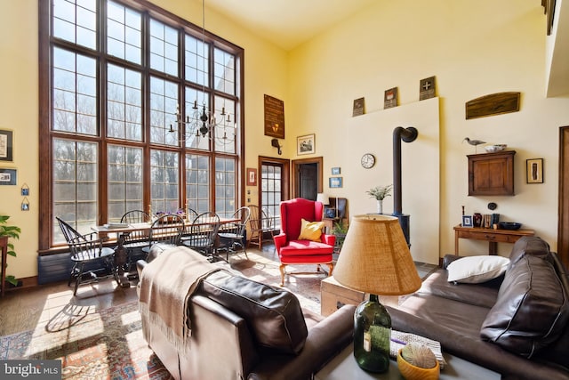 living area with a wealth of natural light, a wood stove, and a high ceiling