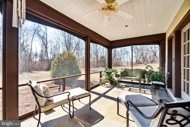 sunroom / solarium with a ceiling fan and wooden ceiling