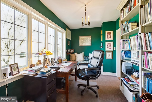 carpeted office with a chandelier and baseboards