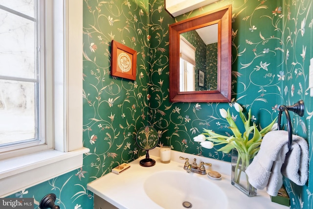 bathroom featuring wallpapered walls, vanity, and a healthy amount of sunlight