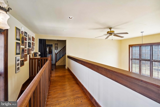 hall with dark wood-style floors, baseboards, an upstairs landing, and recessed lighting