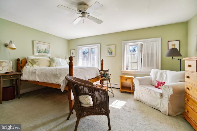 bedroom with ceiling fan, multiple windows, baseboard heating, and light colored carpet