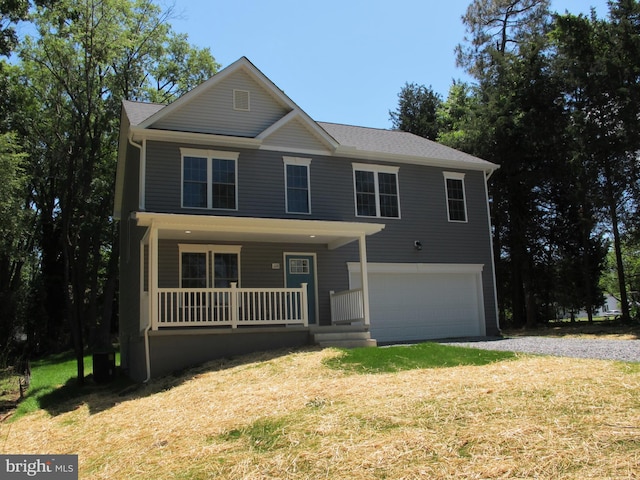 view of front facade with a garage, driveway, a porch, and a front yard