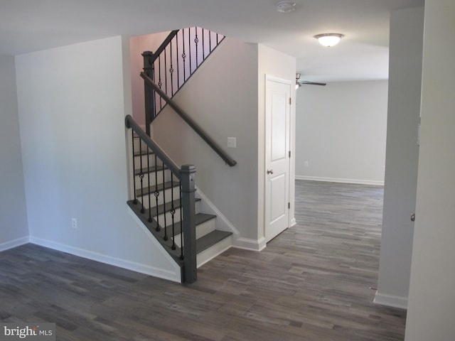 stairway featuring a ceiling fan, baseboards, and wood finished floors