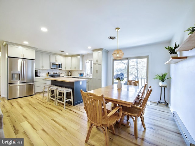 dining area with recessed lighting, visible vents, light wood-style flooring, and a baseboard radiator