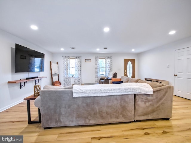 living room featuring recessed lighting, baseboards, and light wood finished floors