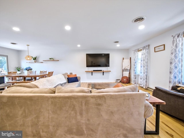 living area with light wood-type flooring, visible vents, and recessed lighting