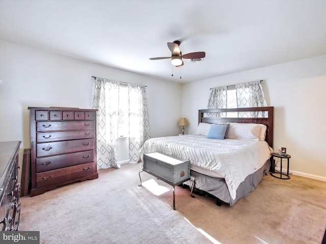 carpeted bedroom with ceiling fan and baseboards