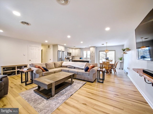 living room featuring recessed lighting, visible vents, and light wood-style floors