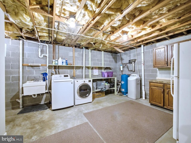 unfinished below grade area featuring a sink, washing machine and dryer, and freestanding refrigerator