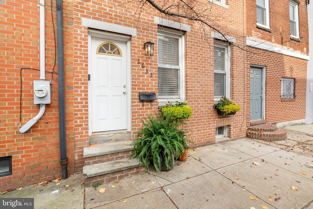 entrance to property with a patio and brick siding