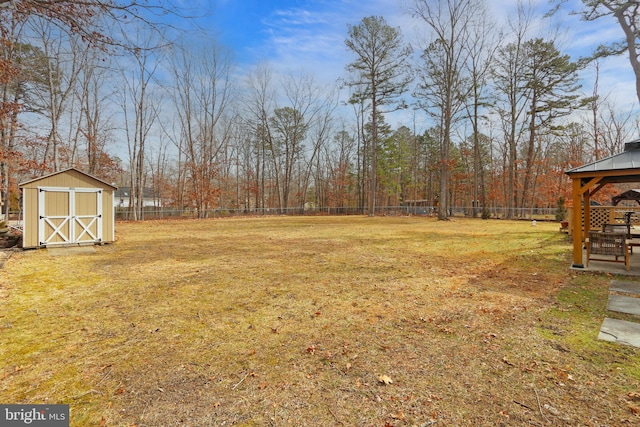 view of yard with an outbuilding, a gazebo, a storage unit, and a fenced backyard