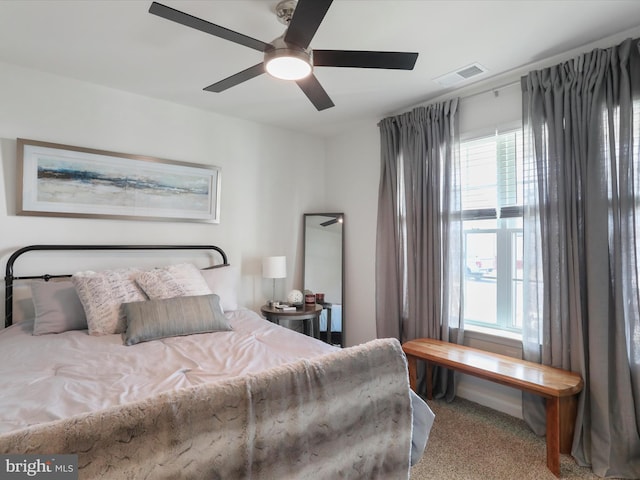 carpeted bedroom featuring a ceiling fan and visible vents